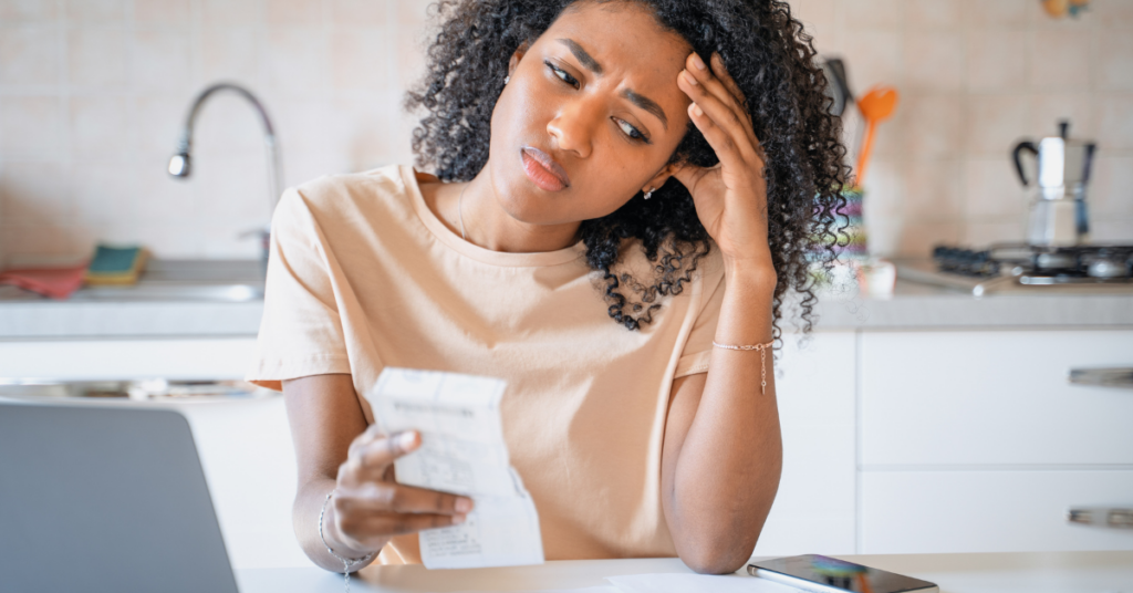 overwhelmed young woman at table with credit card debt