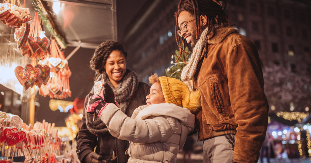 young mother and father with their daughter using a personal loan at a christmas market