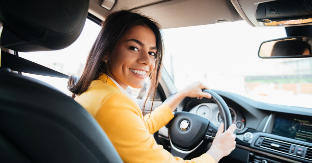 smiling woman in yellow shirt driving