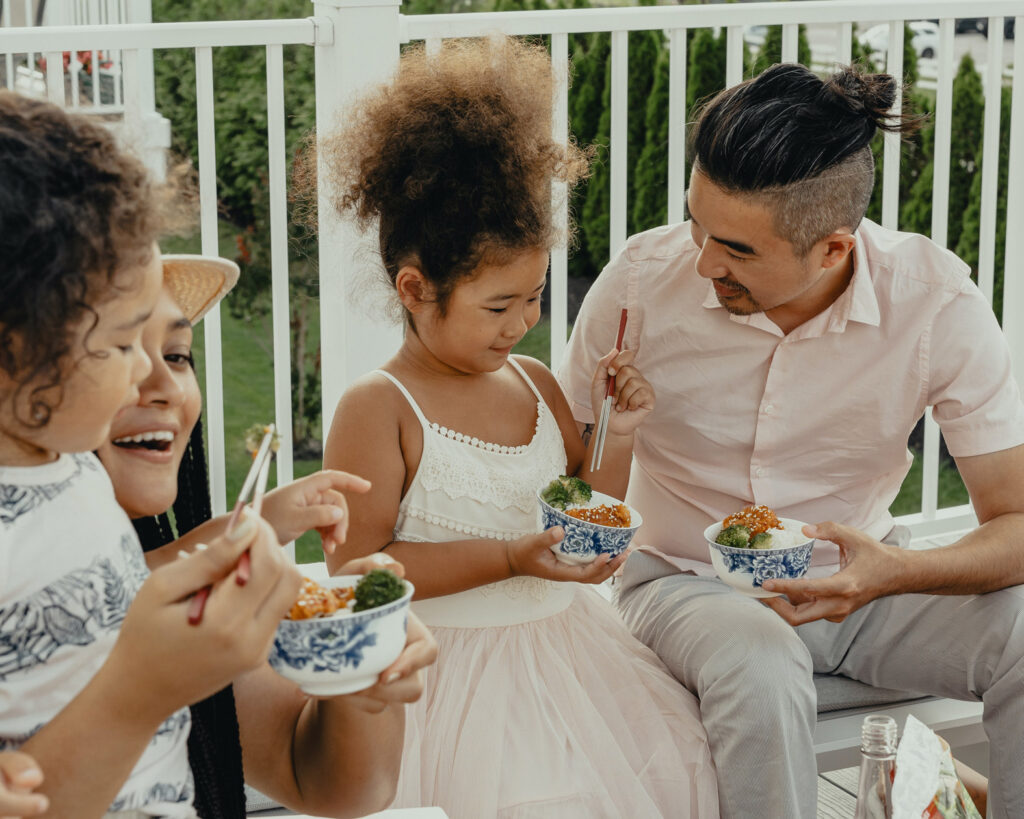 A family of four enjoying a meal together on their deck