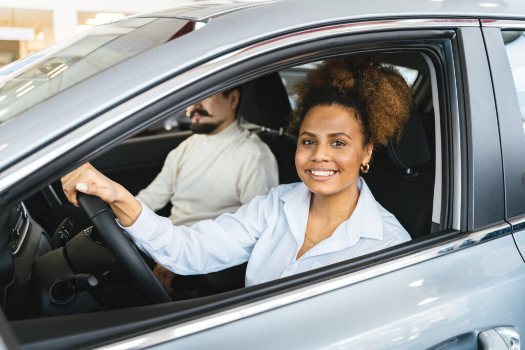 Woman smiling as she takes a car out for a test drive.