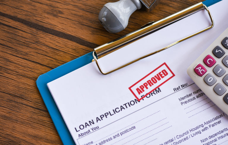loan application form with "APPROVED" stamped on the forms in red