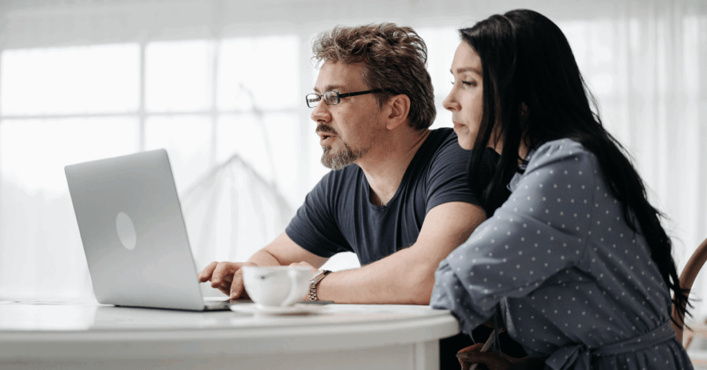Early 30s couple looking at a laptop together
