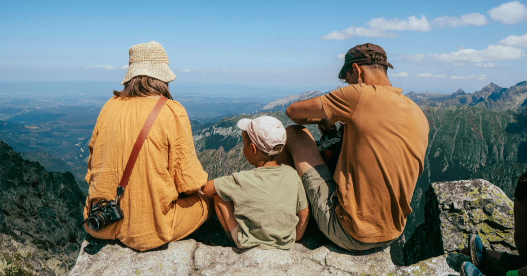 A family of 3 resting during their hiking trip